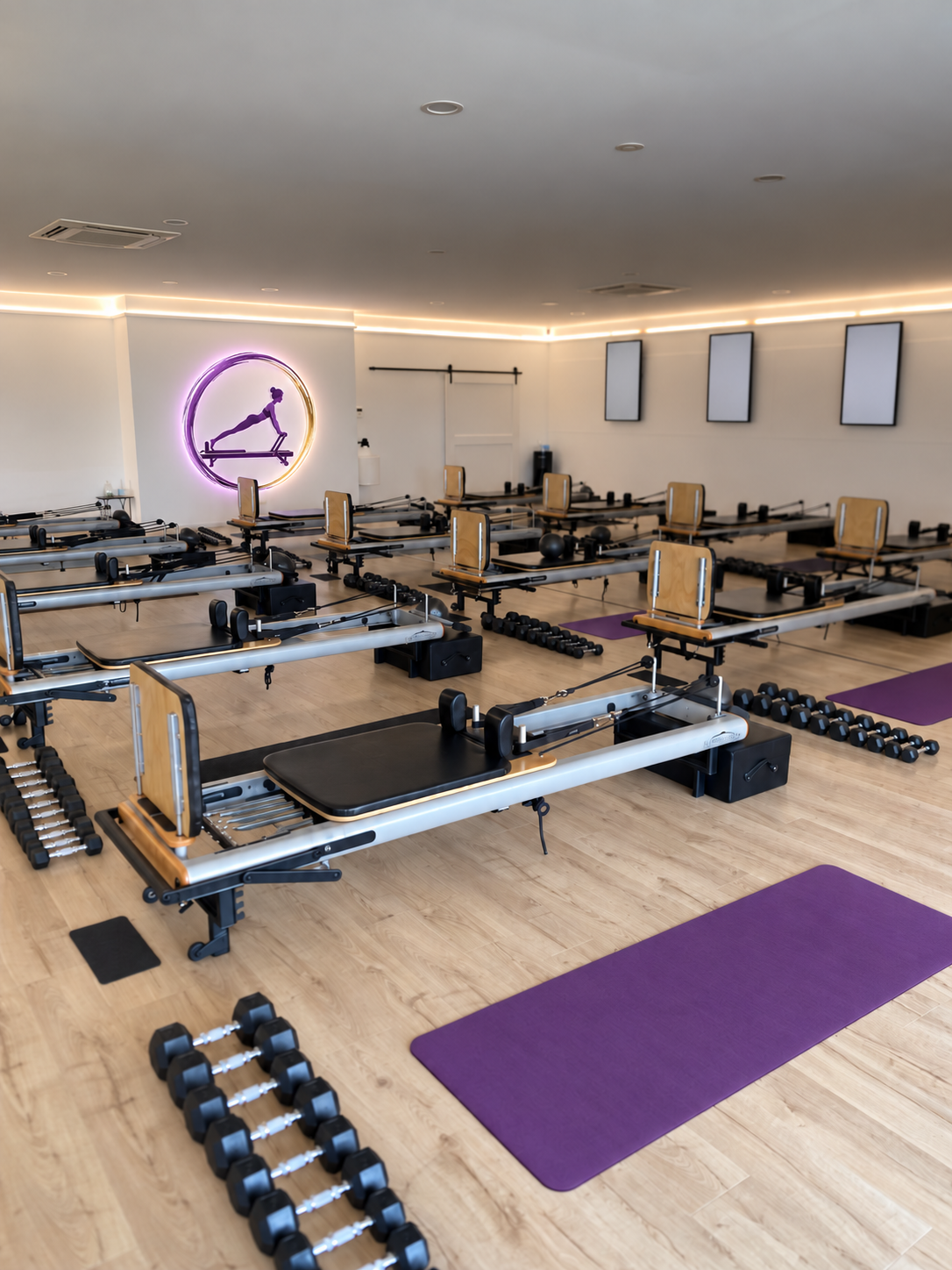 The Room 2 Move studio floor with reformers, weights and orchid purple mats
